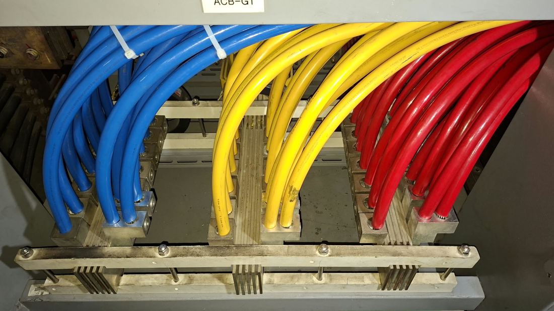 Color-coded cables landed on an ACB bus bar